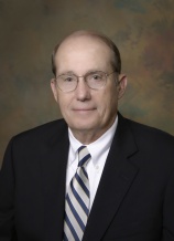 A man in a suit and tie wearing glasses.