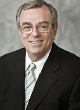 A man in suit and tie smiling for the camera.