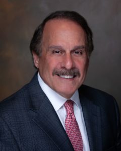A man with a mustache and beard wearing a suit.