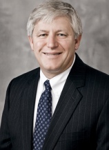 A man in suit and tie smiling for the camera.