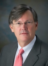 A man in a suit and tie wearing glasses.