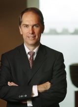 A man in suit and tie with his arms crossed.