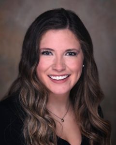 A woman with long hair smiles for the camera.